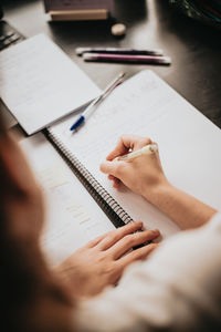 Cropped hands of woman using laptop at table