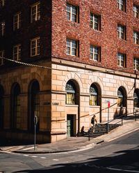 People walking on street by building in city