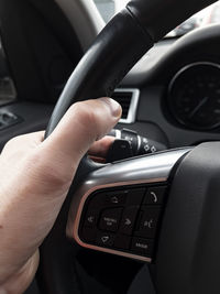 Cropped hand of man driving car