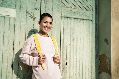 Smiling woman with short hair in front of old door