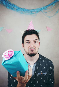 Portrait of young man standing against wall