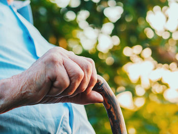 Midsection of senior man holding walking cane