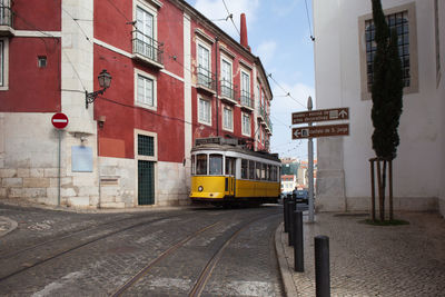 Vehicles on road against sky in city