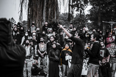 People standing on street by trees in city