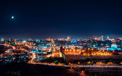 High angle view of illuminated city against sky at night