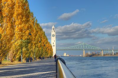 Autumn trees and clock tower by bridge over st lawrence river