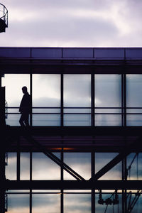 Silhouette man standing at airport against sky during sunset
