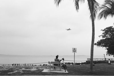 Man flying over sea against sky
