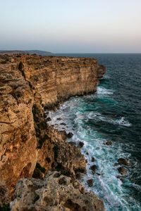 Scenic view of rocks in sea against sky