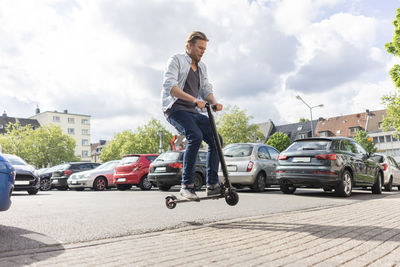 Man on e-scooter jumping in the air