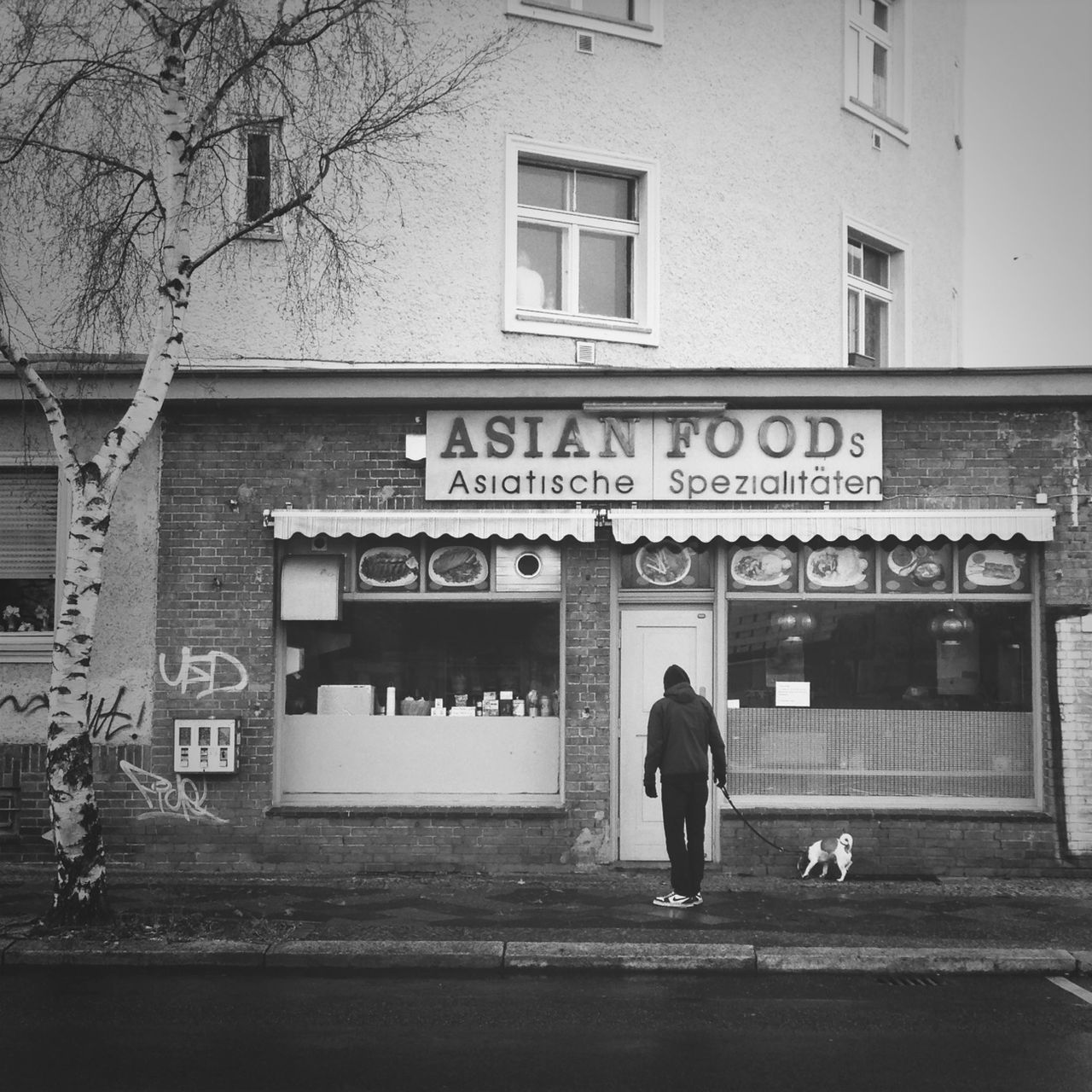 text, architecture, built structure, building exterior, western script, men, walking, communication, full length, street, lifestyles, city, person, city life, building, leisure activity, non-western script, sign