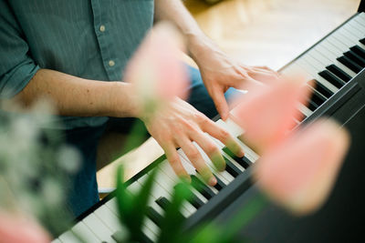 Midsection of man playing piano