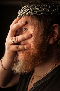 Close-up portrait of woman covering face with hand