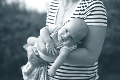 Midsection of mother holding cute baby boy