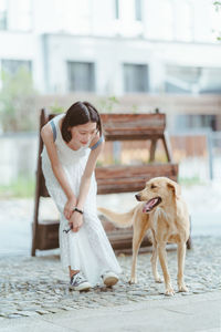 Young woman with dog sitting on floor