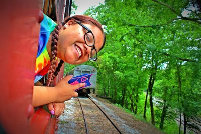 Portrait of happy woman looking through train window
