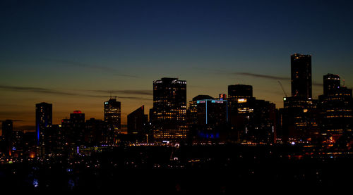 Illuminated buildings against sky at night