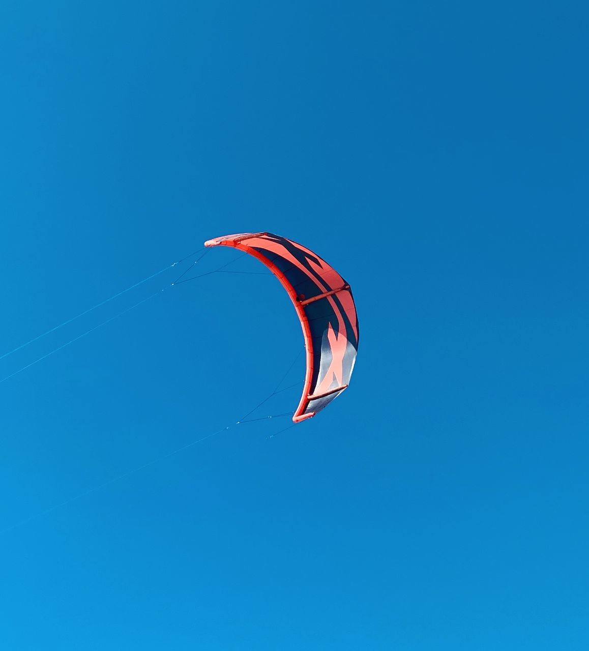 blue, windsports, sports, sky, flying, clear sky, mid-air, toy, nature, low angle view, paragliding, parachute, extreme sports, adventure, leisure activity, copy space, day, kite sports, joy, motion, sunny, sport kite, environment, outdoors, kite - toy, wind, transportation, gliding, multi colored, no people, exhilaration
