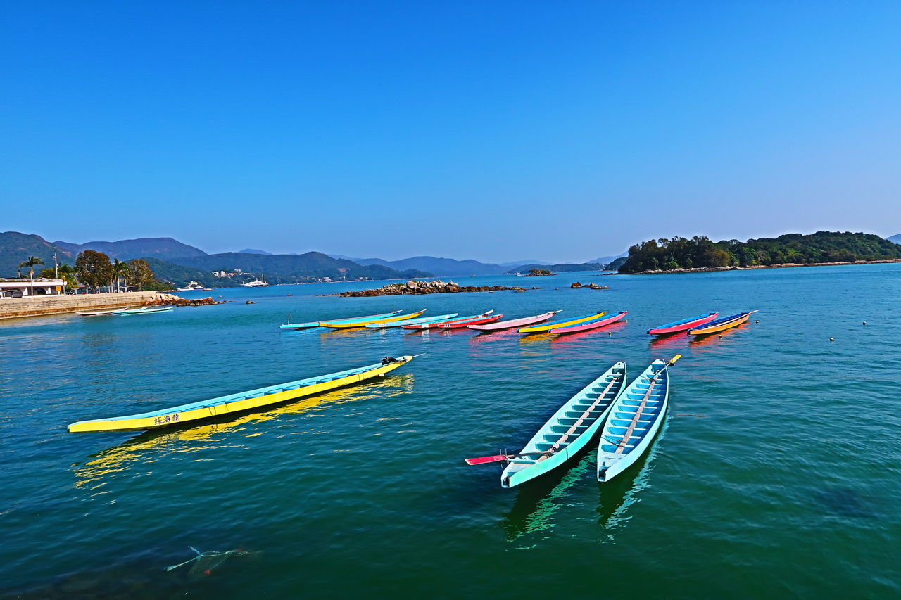 BOAT MOORED ON SEA AGAINST CLEAR BLUE SKY