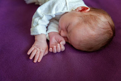 High angle view of baby lying on bed