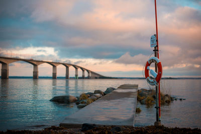 Bridge over river against sky during sunset