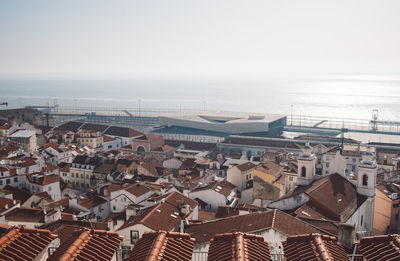 High angle view of townscape by sea against sky