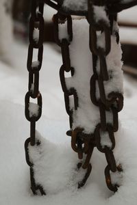 Close-up of snow on metal chain during winter