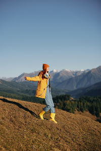 Full length of woman standing on field against clear sky