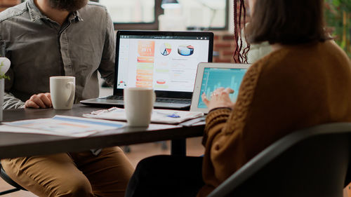 Midsection of woman using laptop on table