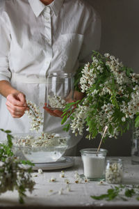 Midsection of woman holding potted plant on table