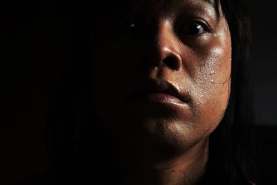 Portrait and close up sweaty face and the tears of long-haired asian men on a black background