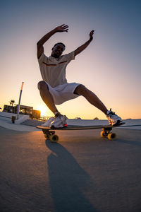 Low section of man skateboarding on road
