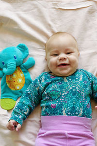 Smiling three month old baby in pink pants on a diaper. top view.