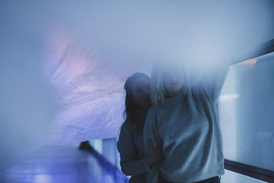 Young woman with friend holding plastic