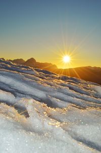 Scenic view of snow covered landscape against sky during sunset