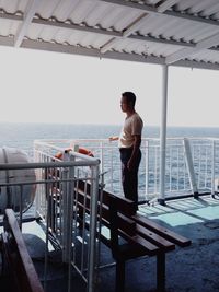 Man standing on pier at sea
