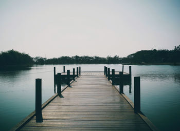 Pier over lake against clear sky