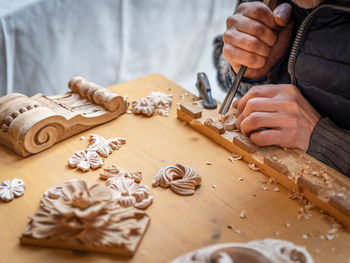 Midsection of man carving wood