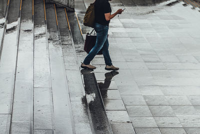 Low section of woman standing on footpath