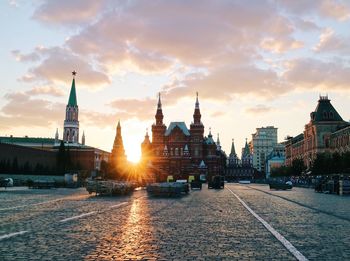 View of city street and buildings at sunset