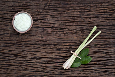 Close-up of spring onion and cream on table