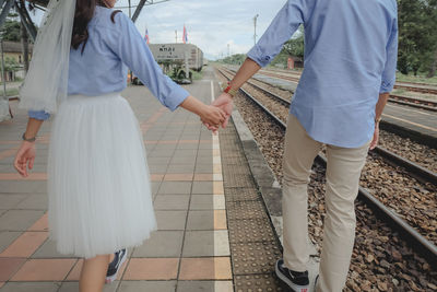 Low section of man and woman standing on sidewalk