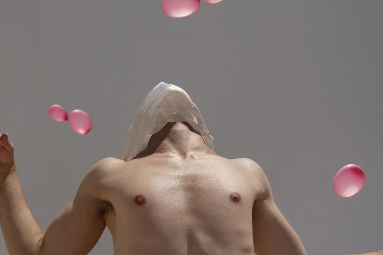 shirtless, one person, lifestyles, men, indoors, front view, studio shot, portrait, standing, leisure activity, males, real people, body part, human body part, adult, balloon, strength, gray, chest, human face