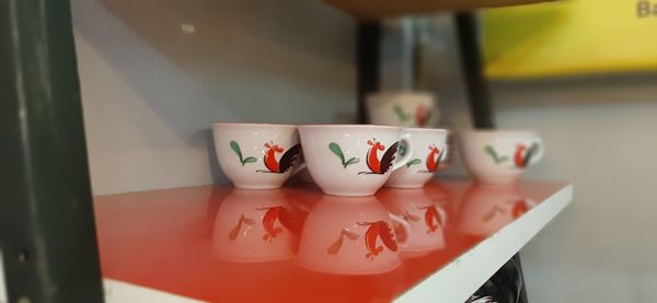 Close-up of tea cups on shelf