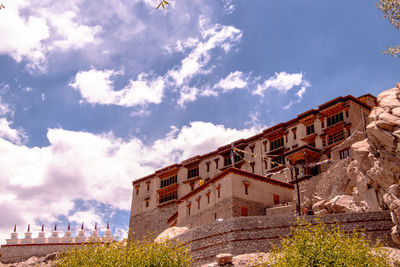 Low angle view of buildings against cloudy sky