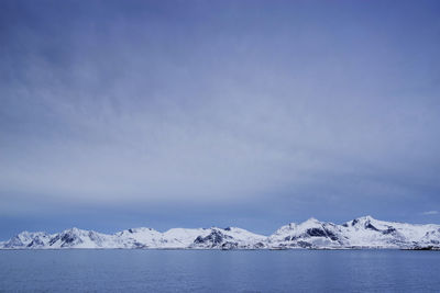 Scenic view of snowcapped mountains by sea against sky