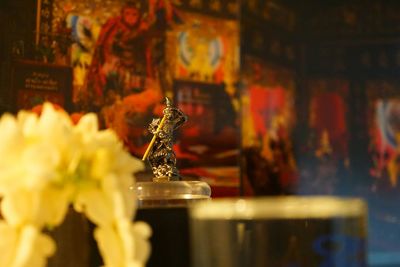 Close-up of buddha statue on table in temple