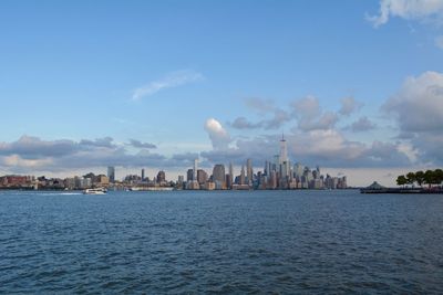 Buildings in city against cloudy sky