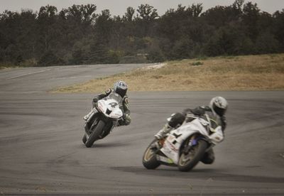 View of people riding motorcycle on road