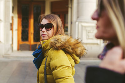 Portrait of young woman wearing sunglasses standing outdoors